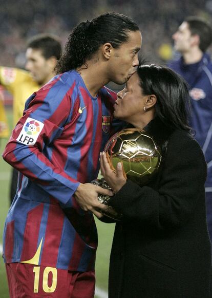 Ronaldinho Gaúcho beija sua mãe enquanto segura a Bola de Ouro, entregue pela revista francesa France Football, em 2005.