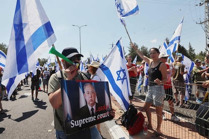 Un manifestante sostiene un cartel de protesta contra la reforma judicial del primer ministro israelí Benjamin Netanyahu.