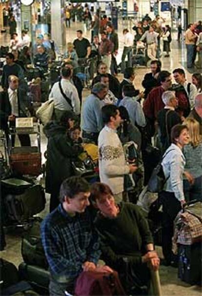 Decenas de pasajeros hacían cola ayer en el aeropuerto de Barajas.