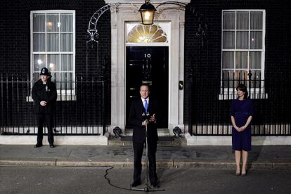 David Cameron es observado por los medios y su esposa Samantha ante la fachada del 10 de Downing Street.