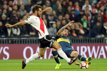 El centrocampista de River Plate, Leonardo Ponzio, intenta controlar el balon ante la entrada del centrocampista de Boca Juniors, Pablo Pérez.