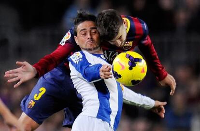 Piqué pelea un balón con Sergio García.