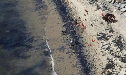 Un grup de voluntaris omplen galledes amb cru prop de la platja de Refugio després del trencament de l'oleoducte al nord de Goleta, Califòrnia.