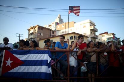 Banderas cubanas y norteamericanas entre el público que espera la llegada de John Kerry a Cuba para la reapertura de la embajada de EE UU en La Habana.