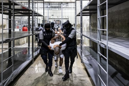 Guardias penitenciarios escoltan a un hombre deportado de Estados Unidos a una prisión en El Salvador, el 12 de abril.