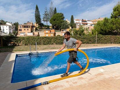 Un operario rellana la piscina de una urbanización de la localidad de Rincón de la Victoria, en Málaga.