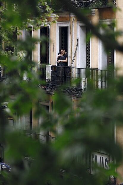 La ternura se adueña de los balcones. Un abrazo en la calle de San Millán de Madrid.