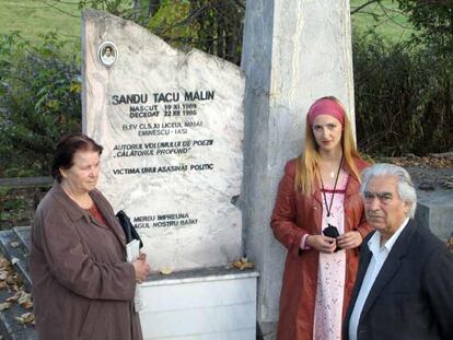 Ana, Alina y Alexander Tacu frente a la lápida de su hijo, Malin, en el cementerio de Iasi.