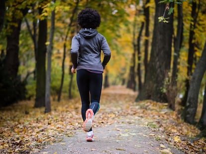 A woman runs through a park.