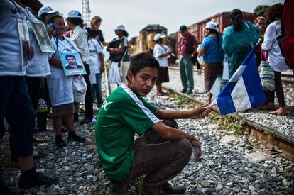 Al paso de la caravana por la estación ferroviaria de Ixtepéc, decenas de migrantes decidieron acompañarlas a las vías. En la imagen, un menor migrante “no acompañado” sostiene una bandera hondureña sentado en los raíles.