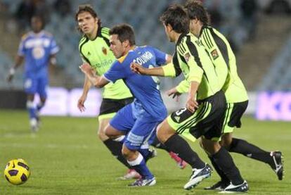 El delantero del Getafe Colunga lucha por el balón con varios jugadores del Zaragoza.