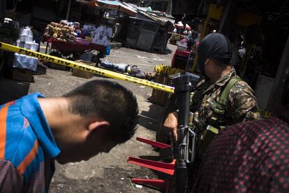 Homicidio en las afueras del mercado central de San Salvador, frente a la iglesia de El Calvario. Supuestamente el homicidio se produjo porque la victima se negó a pagar del alquiler exigido por la pandilla. Solamente durante 2016, El Salvador registró una tasa diaria de 14 asesinatos. Las pandillas han reestructurado la forma en que viven los salvadoreños: el estrés está por todas partes. Puede ser percibido por la imagen de alambre de espino alrededor de los tejados de las casas, las cerraduras en todas las puertas, las medidas de precaución que todos tienen tomar antes de salir de tu casa o tomar el autobús y, sobre todo, por todos los guardias armados fuera de cada tienda . No puedes caminar más de media milla sin ver una arma de fuego.