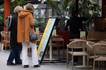 Dos mujeres leen la carta de menú de un restaurante del centro de Barcelona.