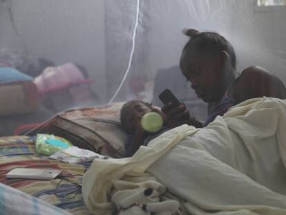 Una joven madre y su hijo se recuestan bajo una red para mosquitos en un refugio luego que el huracán María impactara a Dominica