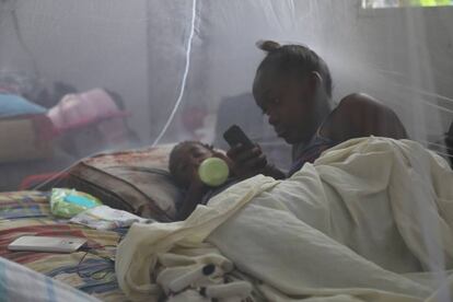 Una joven madre y su hijo se recuestan bajo una red para mosquitos en un refugio luego que el huracán María impactara a Dominica