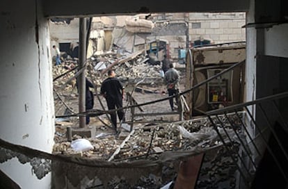 Varios iraquíes inspeccionan las casas próximas al restaurante de Bagdad, destrozado ayer por una bomba.