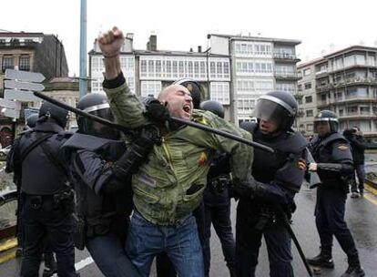 El independentista Carlos Morais, que resultó herido grave, es reducido por varios policías.