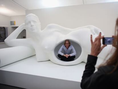 Un visitante de la feria de arte Frieze es fotografiado en una escultura de Jennifer Rubell.