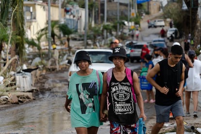 Jóvenes caminan en una zona afectada por el huracán 'Otis' en Acapulco, el 28 de octubre.