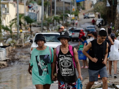 Jóvenes caminan en una zona afectada por el huracán 'Otis' en Acapulco, el 28 de octubre.