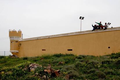 Un grupo de niños saluda desde el centro de menores de La Purísima, en Melilla, un antiguo fuerte militar.