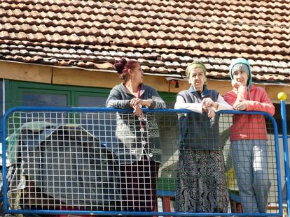Tres mujeres se asoman al balcón para observar la inauguración de la entrega de llaves de ocho viviendas del proyecto Roma Action.
