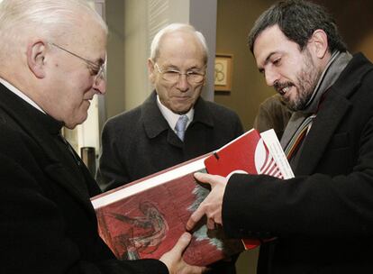 El deán de la catedral, José María Díaz, recibe de manos de Ignacio Santos y en presencia del traductor, un ejemplar de lujo.
