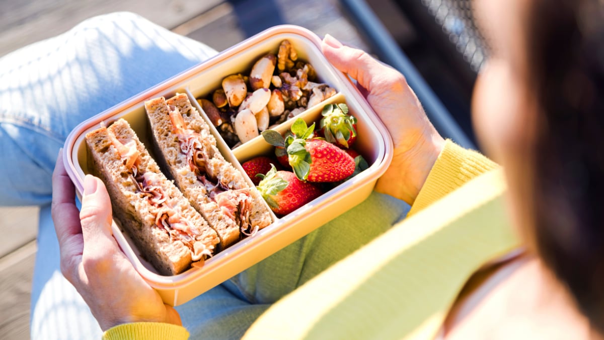 Lunch box with sandwiches, strawberries and nuts.