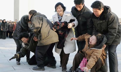 Unas mujeres se desmayan mientras participan al velatorio por la muerte de Kim Jong-il.