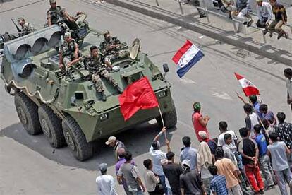 Varias personas impiden el paso de un tanque mientras decenas de miles de manifestantes toman las calles de Katmandú. El rey ha vuelto a ordenar hoy un toque de queda de 18 horas en la capital y las zonas aledañas para impedir una manifestación convocada para mañana por la oposición prodemocrática.