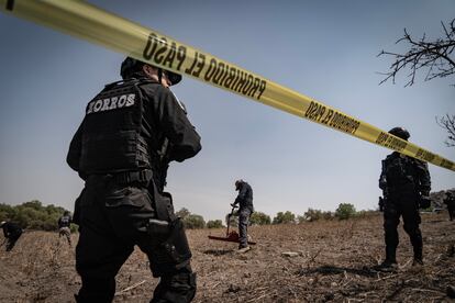 Policías hacen guardia durante la búsqueda a los pies del volcán.