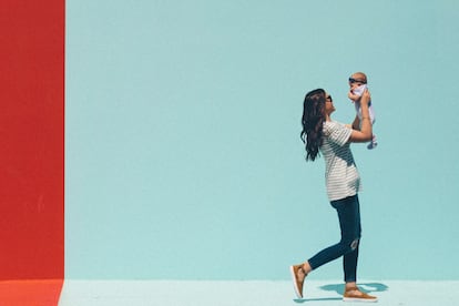 Una madre admira y juega con su bebé.