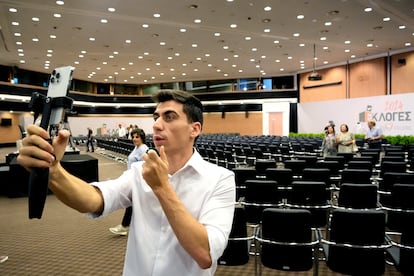 Popular YouTuber and TikToker Fidias Panayiotou holds his cell phone after his proclamation as the winner of one of six seats allotted to Cyprus in the EU Parliament.