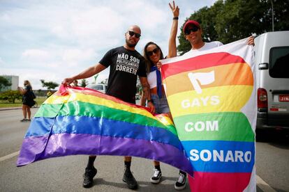 Manifestantes seguram bandeira com as cores do arco-íris e a frase "Gays com Bolsonaro", em 17 de maio, Dia Internacional de Combate à Homofobia e Transfobia.