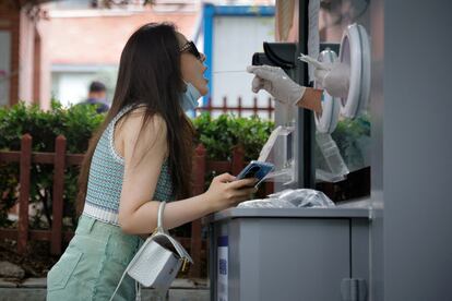 A woman passes a coronavirus control in Beijing on June 28.