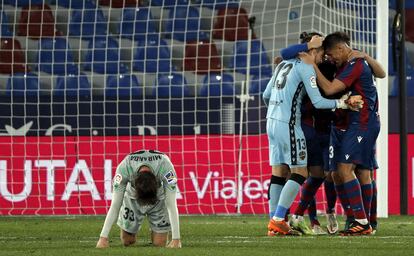Los jugadores del Levante celebran la victoria con Miranda arrodillado sobre el césped.