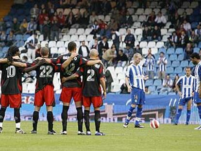 Los jugadores del Levante, abrazados en el círculo central al inicio del partido.