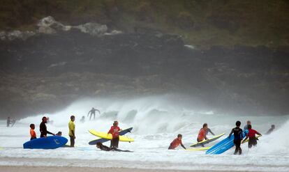 Alumnos de una escuela de surf practican este deporte en la playa de Fistral en Cornwall (Reino Unido), el 5 de agosto de 2015.