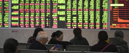 Un grupo de personas observa un panel con la evolución de los mercados bursátiles, en Chengdu, provincia de Sichuan (China).
