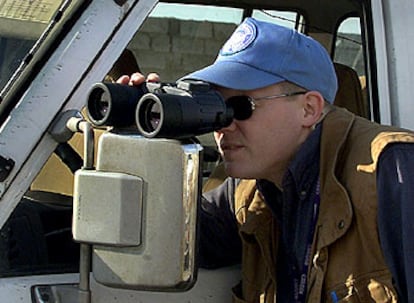 Un miembro de la Unmovic mira por unos prismáticos en una instación militar iraquí en Bagdad.