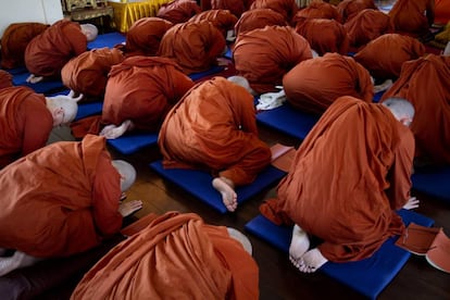Un grupo de monjas novicias budistas recién ordenadas rezan en el templo Songkdhammakalayani.