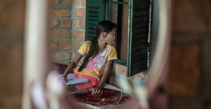 Una niña observa cómo su madre habla con una trabajadora social en Phon Chantorn, Camboya.