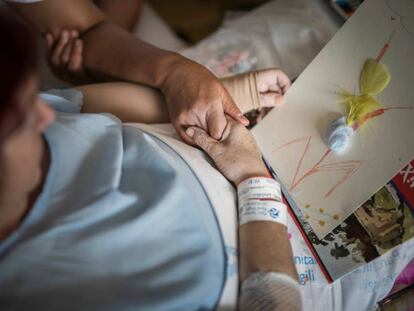 La Lourdes agafa la mà de la seva artterapeuta, amb el dibuix titulat “Resistiré”.