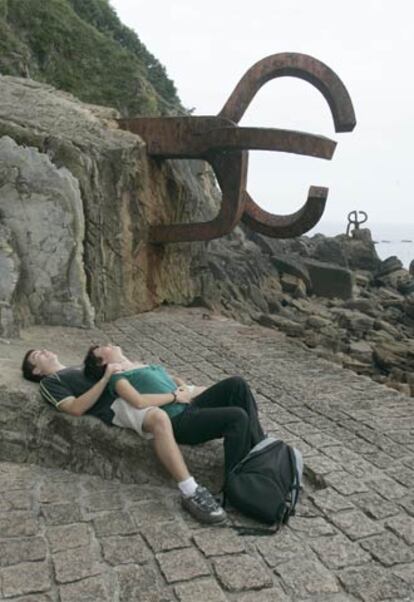 Una pareja junto al <i>Peine del viento,</i> de Eduardo Chillida, en San Sebastián.