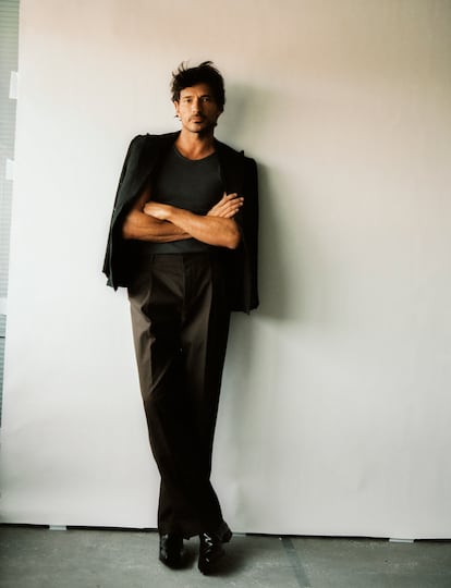 Andrés Velencoso, con chaqueta de Polo Ralph Lauren, pantalón marrón con pliegues de Hermès, camiseta de OnTracks y botas de piel de Prada.