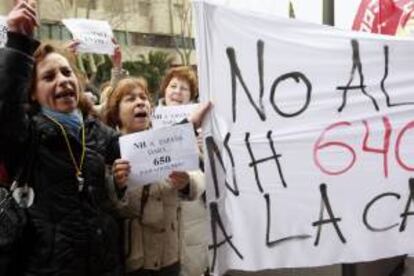 Varias mujeres sostiene una pancarta durante la concentración que trabajadores de NH Hoteles han llevado a cabo hoy a las puertas de uno de los hoteles de la compañía en Madrid, en contra del Expediente de Regulación de Empleo (ERE) que ha planteado la empresa y que afecta en la capital a 325 trabajadores.