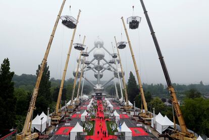 Diez mesas, con capacidad para un total de 220 ​​personas, están suspendidas de grúas a una altura de 40 metros delante del Atomium, como parte de los actos para celebrar 10 años del evento conocido como 'Cena en el Cielo', en Bruselas (Bélgica).