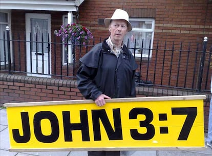 Frank Hogan camina por la calle Sean MacDermott, en Dublín, después del partido de fútbol entre Dublin y Derry All-Ireland, el 11 de agosto de 2007. La cita bíblica (Juan 3:7) del cartel reza: "No te asombres cuando te digo que debes nacer otra vez".