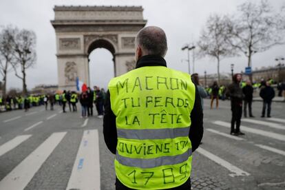 Um manifestante mostra seu colete amarelo com a inscrição "Macron, você está perdendo a cabeça. Lembre-se de 1789" durante a marcha em Paris.