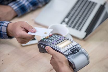 File image of a man using a credit card in a purchase